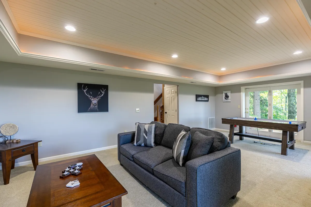 This scene spotlights a stylish, cozy space equipped with a pool table, comfortable seating, large windows, and warm decor. The layout suggests a perfect environment for friendly competition, casual gatherings, and relaxed entertainment with friends or small groups.